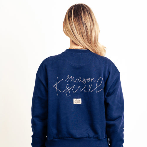 Vue de dos du sweat Maison Ksual bleu marine affichant la grande broderie blanche cursive et l'étiquette logo rectangulaire.